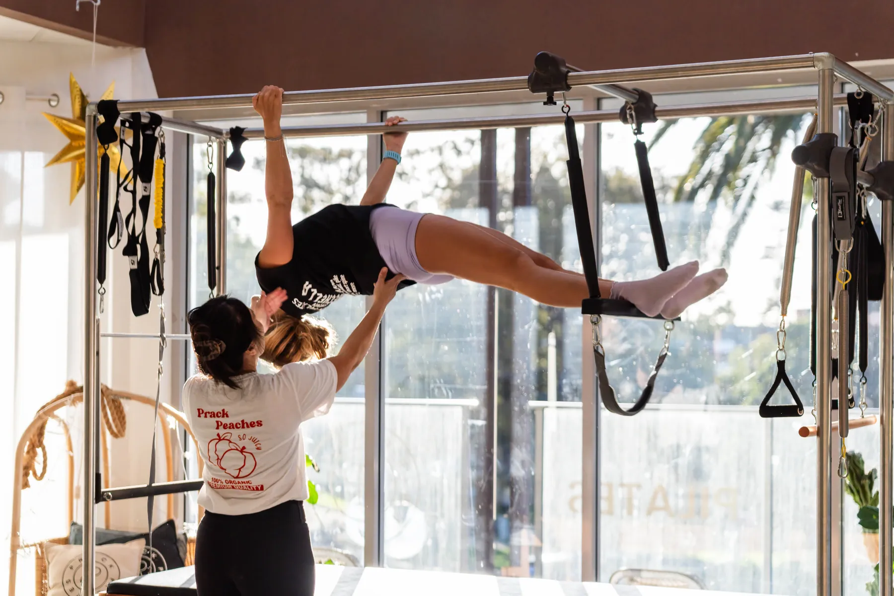 A client suspended from the Cadillac's push-through bar while an instructor supports them from below